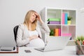 Pregnant woman at the office having headache