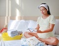 Pregnant woman packing baby clothes for going to hospital Royalty Free Stock Photo