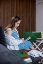 Pregnant woman is packing baby clothes for going to maternity hospital. Woman taking notes Royalty Free Stock Photo