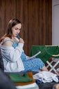 Pregnant woman packing bag for maternity hospital, making notes, checking list in diary. Expectant mother with suitcase of baby Royalty Free Stock Photo