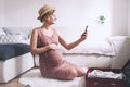 Pregnant woman packing suitcase for hospital or journey, getting ready for newborn baby, labor, making list or taking photo with Royalty Free Stock Photo