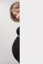 Pregnant woman peeking out of white wall Royalty Free Stock Photo