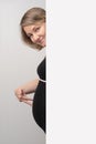 Pregnant woman peeking out of white wall Royalty Free Stock Photo