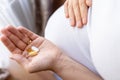 Pregnant woman pills vitamin. Happy smiling woman taking pill with supplement vitamin Omega 3. Vitamin D, E, A Fish Oil Royalty Free Stock Photo