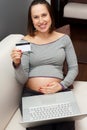 Pregnant woman with plastic card and laptop Royalty Free Stock Photo