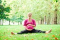 Pregnant woman playing yoga at the Hyde Park, London