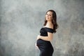 Pregnant woman portrait. Beautiful lady wearing black dress smiling Royalty Free Stock Photo