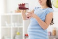 Pregnant woman pouring fruit smoothie at home Royalty Free Stock Photo