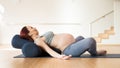 Pregnant woman is engaged in yoga. Reclined Bound Angle Pose or Supta Baddha Konasana