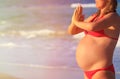 Pregnant woman practicing yoga at beach Royalty Free Stock Photo