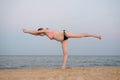 Pregnant woman practicing yoga on the beach. Soft evening light Royalty Free Stock Photo