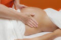 Pregnant woman at prenatal massage, glamour clarity effect Royalty Free Stock Photo