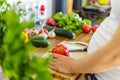Pregnant woman preparing healthy food, holding red pepper on cutting board Royalty Free Stock Photo