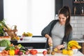 Pregnant woman preparing healthy food with lots of fruit and vegetables at home Royalty Free Stock Photo