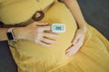 Pregnant woman with pulse oximeter on finger. Doctor measuring oxygen saturation level while visiting expectant mother Royalty Free Stock Photo