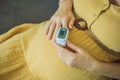 Pregnant woman with pulse oximeter on finger. Doctor measuring oxygen saturation level while visiting expectant mother Royalty Free Stock Photo