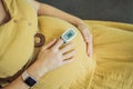 Pregnant woman with pulse oximeter on finger. Doctor measuring oxygen saturation level while visiting expectant mother Royalty Free Stock Photo