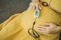 Pregnant woman with pulse oximeter on finger. Doctor measuring oxygen saturation level while visiting expectant mother Royalty Free Stock Photo