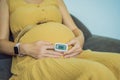 Pregnant woman with pulse oximeter on finger. Doctor measuring oxygen saturation level while visiting expectant mother Royalty Free Stock Photo