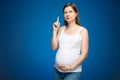 Pregnant woman with question face expression as a symbol of the gender of a baby. Gender party preparations