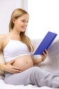 Pregnant woman reading book at home Royalty Free Stock Photo