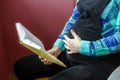 A pregnant woman is reading a book. Waiting for childbirth. Concept of life style, motherhood, reading, family.