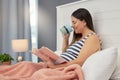 Pregnant woman, reading and tea and book in home bedroom for education and development. Person with mockup story and Royalty Free Stock Photo