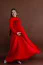 Pregnant woman in red flying dress holding her belly Royalty Free Stock Photo