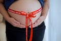 Pregnant woman with red ribbon