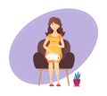 Pregnant lady is sitting in armchair with cat