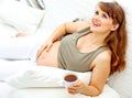 Pregnant woman relaxing on couch with cup of tea Royalty Free Stock Photo