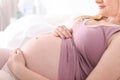 Pregnant woman resting on bed in light room Royalty Free Stock Photo