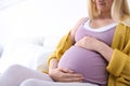 Pregnant woman resting on bed in light room Royalty Free Stock Photo