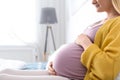 Pregnant woman resting on bed in light room, closeup Royalty Free Stock Photo