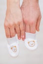 Pregnant woman`s belly with baby socks,mother hand holding newborn baby sock, Royalty Free Stock Photo