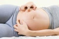 Pregnant woman scratching belly because itchy skin which causes striped- Pregnancy medicine concept