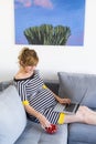A pregnant woman in a semi-sitting position eating strawberries and using laptop Royalty Free Stock Photo