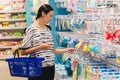 Pregnant woman shopping in baby store. Woman choosing baby stuff at baby shop store Royalty Free Stock Photo