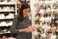 Pregnant woman shopping shoes for her baby girl. Mother doing shopping in baby shop Royalty Free Stock Photo