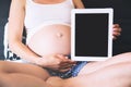 Pregnant woman showing blank digital tablet screen Royalty Free Stock Photo