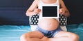 Pregnant woman showing blank digital tablet screen Royalty Free Stock Photo