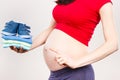 Pregnant woman showing clothing for newborn, concept of expecting for baby Royalty Free Stock Photo