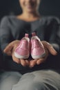 Pregnant woman showing cute baby shoes Royalty Free Stock Photo