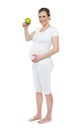 Pregnant woman showing fresh green apple Royalty Free Stock Photo