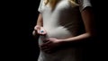 Pregnant woman showing pills, pharmacological supplement during trimester