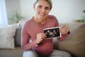 Pregnant woman showing ultrasound photo of her baby. Royalty Free Stock Photo