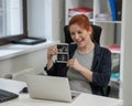 A pregnant woman shows a photo from an ultrasound scan of the fetus via video link in the office. Royalty Free Stock Photo