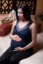 Pregnant Woman Sits on Bed Royalty Free Stock Photo