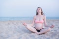 Pregnant woman sitting on a beach and meditates. Soft evening light, deserted beach Royalty Free Stock Photo