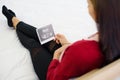 Pregnant woman sitting on bed and looking at her ultrasound image of her child in her belly Royalty Free Stock Photo